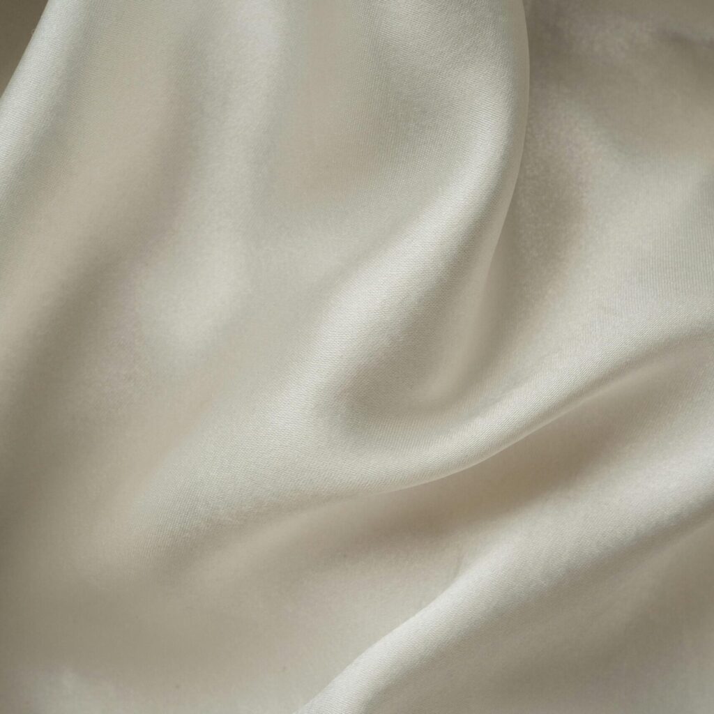 Home Close-up of smooth white silk fabric with soft folds and gentle draping.